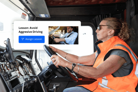 A woman in a safety vest drives a large truck. An overlay shows a Defensive Driver Training lesson titled Avoid Aggressive Driving with a button labeled Assign Lesson.